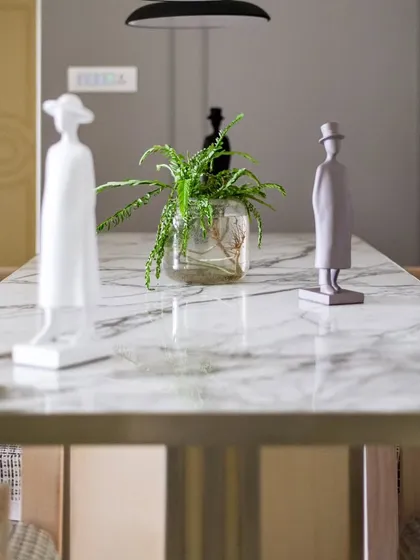 A close-up of the marble dining table, showcasing the beautiful veining of the stone. We believe in using high-quality, natural materials to create timeless spaces.