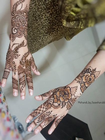 A floral back-hand design with bold, shaded roses and leafy vines.