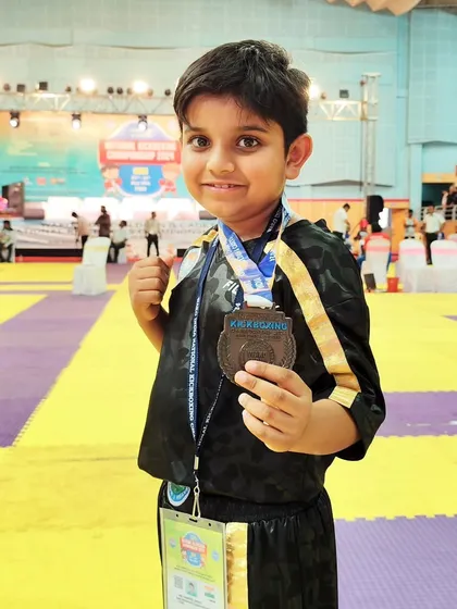 A close up of our young national medalist, Abeer, proudly displaying his bronze medal. His smile reflects the joy of achievement after dedicated training.