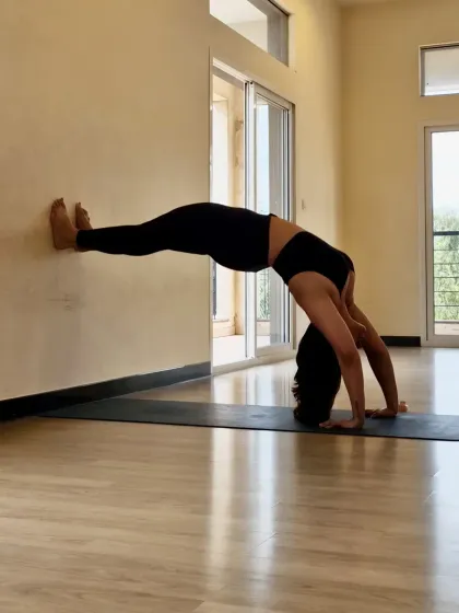 Exploring a wall-assisted Chakrasana, or Wheel Pose. Using props like a wall helps deepen backbends safely, opening the heart and strengthening the entire body. My practice is about using tools to understand our bodies, not force them.
