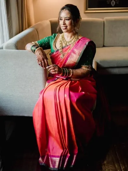 A quiet, reflective moment. The saree's pleats are perfectly arranged, creating a graceful look even when seated.