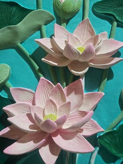 A detailed shot of the lotus mural after the base colors have been applied. The three dimensional quality of the sculpture is already apparent, with the flowers and leaves appearing to lift off the surface.