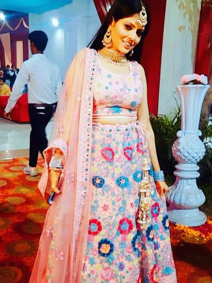 A close-up of another floral lehenga, this one with brighter pink and blue threadwork. It’s a cheerful and festive rental option.
