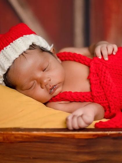 This angle shows the texture of the hand-knitted Santa outfit, which is soft and safe for a newborn's delicate skin.