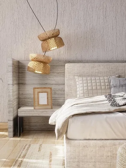 A closer look at the bedside, where a woven pendant light hangs over a simple, modern nightstand. The textured wall and light wood tones enhance the room's calm, natural aesthetic.