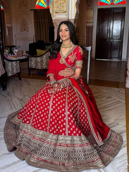 The full view of Aashna's stunning bridal lehenga. The minimal makeup perfectly balances the grandeur of her outfit, ensuring she remains the star of the show.