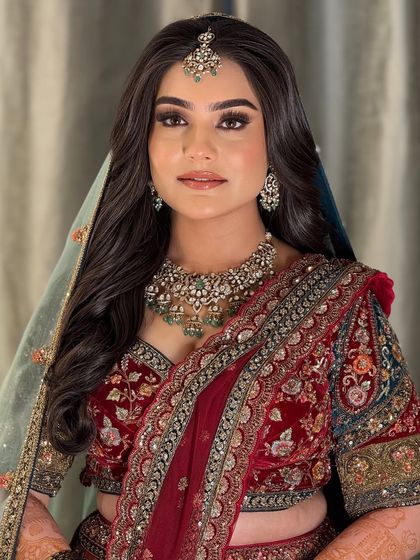 Another angle of the bride's reception look, with a sheer dupatta framing her face. The makeup is designed to look flawless from every angle.