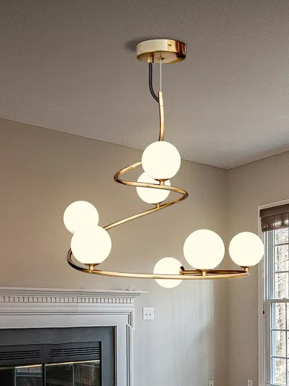 The spiral globe chandelier looks great above a fireplace, adding a modern touch to a classic architectural feature. Its warm light creates a cozy and inviting atmosphere.