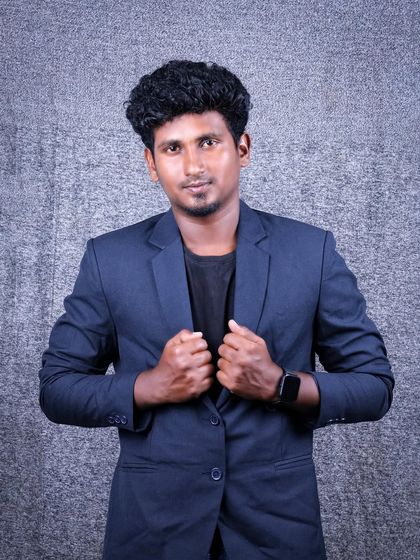 A portrait showing a strong and confident stance. The subject is adjusting his blazer, which creates a dynamic and engaging image suitable for a professional profile.