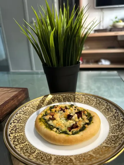 Pizza with a twist. We've created a Palak Paneer Pizza, combining the creamy, spiced flavors of the classic Indian dish with a crispy pizza base.