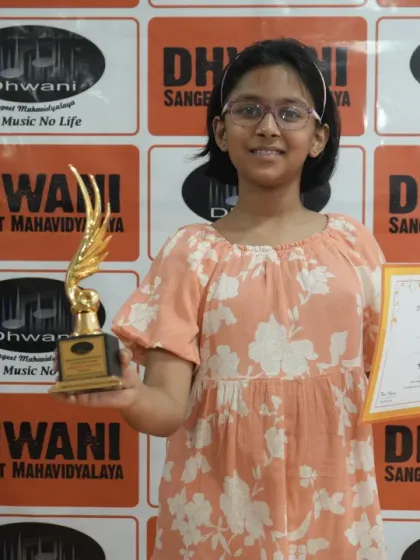 A smiling student proudly presents her trophy and certificate. This is the result of dedicated practice in our drawing and sketching classes.