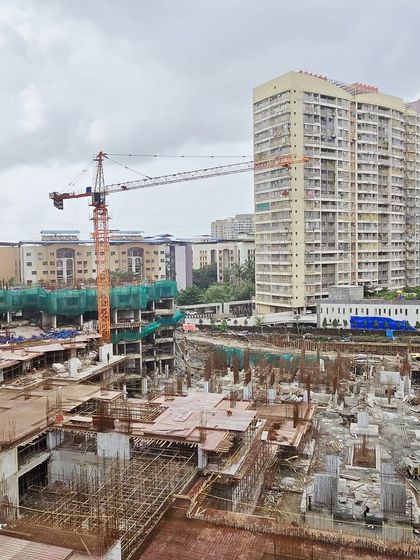 A view of the lower levels of the township under construction, showing the foundation and podium work that supports the towering structures above.