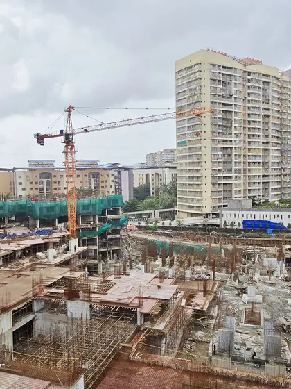 A view of the lower levels of the township under construction, showing the foundation and podium work that supports the towering structures above.