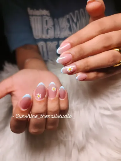 A cute and simple design for shorter nails. This set has a light blue French tip on almond-shaped nails, with a hand-painted daisy on the accent nail.
