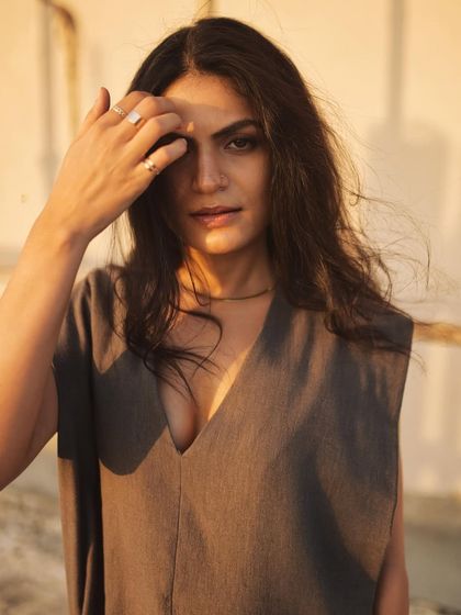 A close-up that feels intimate and authentic, with the hand gesture adding a natural, unposed quality.