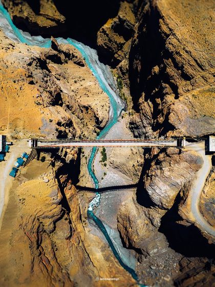 A top-down drone view of the Chicham Bridge in Spiti, Asia's highest bridge. This perspective reveals the scale of the engineering marvel and the dramatic gorge it spans.