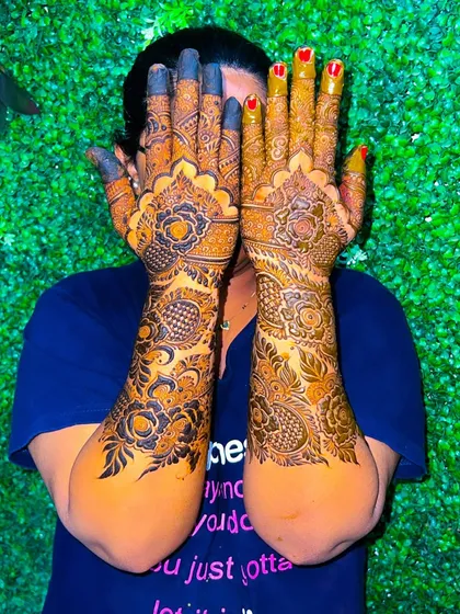 A fun shot of the client showing off her full-arm floral mehendi.