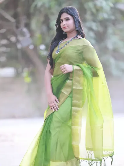A three-quarter shot of the model in the green saree. This pose showcases the delicate fabric and the oxidized silver necklace.