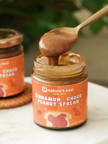 A spoonful of the creamy cinnamon choco peanut spread, showcasing its smooth, luscious texture.