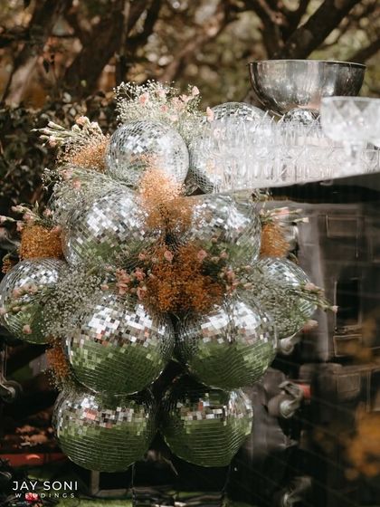 A unique floral accent created by combining shiny disco balls with dried, earthy florals, perfectly capturing the wedding's blend of glamour and rustic charm.