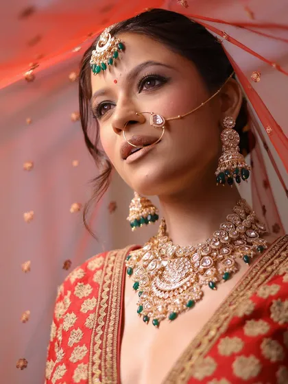 Looking away with a gentle smile, this shot captures the bride's anticipation. The makeup is soft yet defined, perfect for both photographs and in-person moments.
