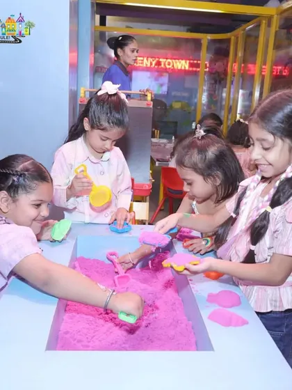 A group of friends gathered around the sensory sand table. This is one of the many dedicated activity zones that keep children entertained during our parties and play sessions.