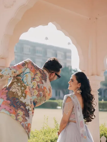 A playful and vibrant moment from a Haldi ceremony at a royal venue. The groom's colorful jacket and the couple's joyful interaction showcase the fun and energy of pre-wedding festivities.