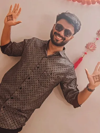 A happy groom celebrating his mehendi ceremony, proudly displaying his simple yet significant henna designs.