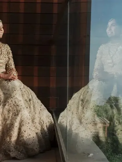 A reflective bridal portrait, with the bride seated by a large window, her image mirrored in the glass.