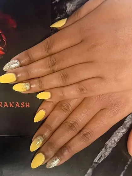 A full view of the bright yellow nails with a silver glitter accent. So cheerful.