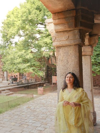 A beautiful solo portrait of the bride-to-be, leaning against an ancient stone pillar and basking in the sunlight.