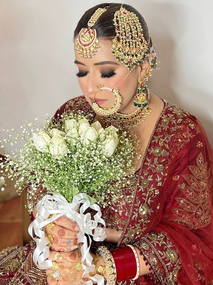 My bride Akanksha holding her beautiful bouquet of white tulips and baby's breath, looking serene and stunning.
