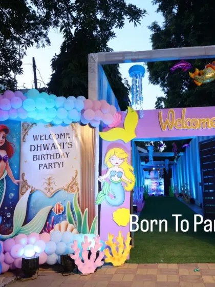 A welcoming entrance for an Ariel-themed party, with a personalized sign and colorful balloon decorations.