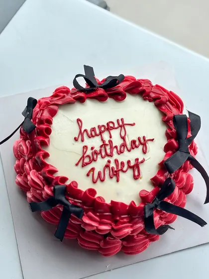 I love a good vintage buttercream moment, and this design with its intricate red piping and delicate black bows is a perfect example. This style is super trendy and adds a touch of classic elegance to a birthday or anniversary celebration.