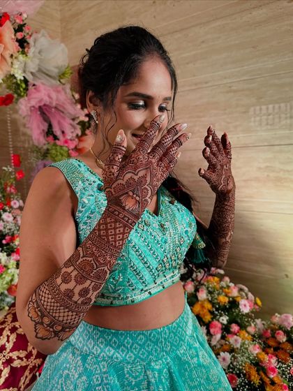A candid shot of a bride's happy reaction to her beautiful mehndi.