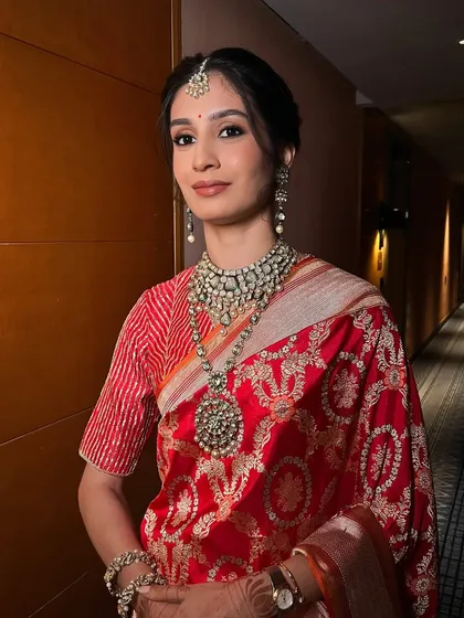 One of my favorite sister of the bride looks. This traditional style with a neat bun, soft glam makeup, and a beautiful red saree is absolutely timeless.