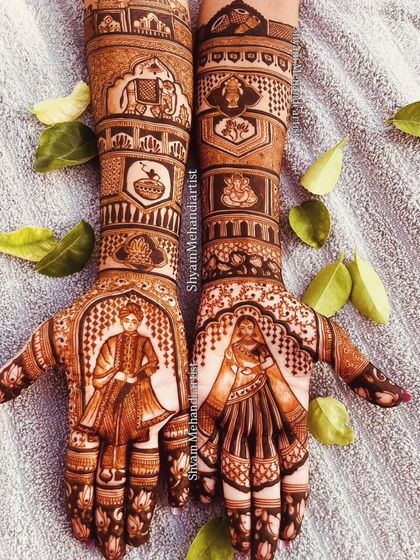 A beautifully styled shot of a bride and groom portrait mehandi, surrounded by green leaves.