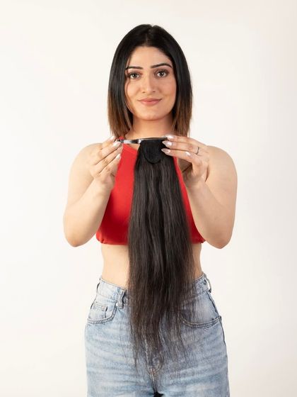 A model holding a ponytail extension, showing the product and its attachment.