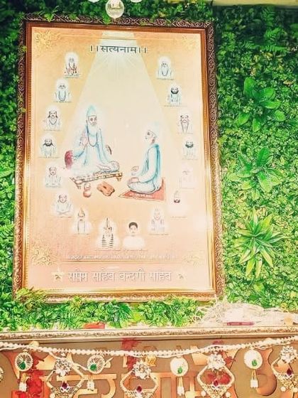 A closer view of the green wall behind the spiritual artwork. The dense, textured greenery makes the framed picture and altar stand out, creating a beautiful and respectful focal point.