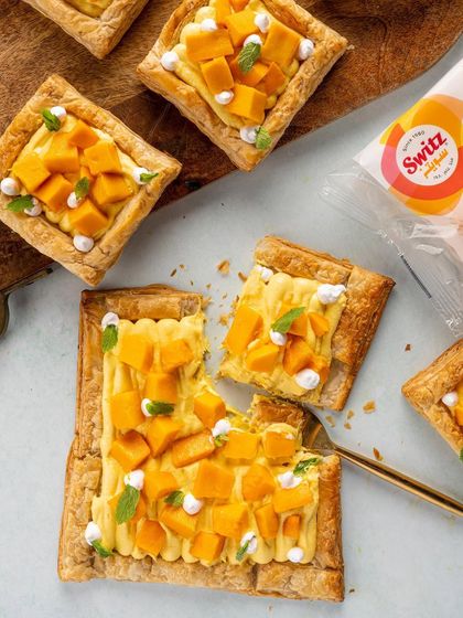 A beautiful flatlay of mango tarts for Switz. This top down shot showcases the product's versatility in a recipe, with fresh mango and mint adding a burst of color and freshness. It’s an inspiring image for a food brand's website or social media.