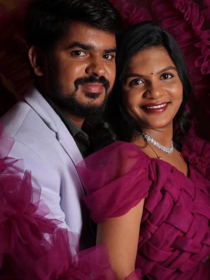 Couple's maternity shoots are a wonderful way to capture your journey together. Here, the partner's light-colored blazer complements the deep magenta of the maternity gown perfectly.