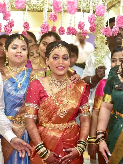 A close-up of the bride's happy face during her entrance. The makeup is kept classic and elegant to complement her traditional attire.