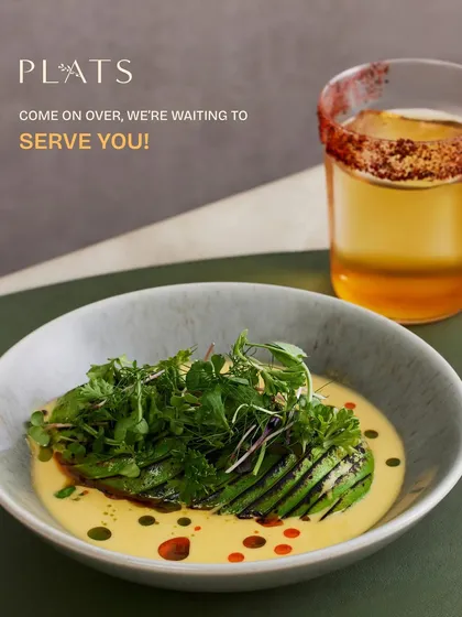 A warm invitation to our table. This dish of grilled avocado in a creamy sauce, paired with a signature cocktail, represents the welcoming and unforgettable experience I strive to create.