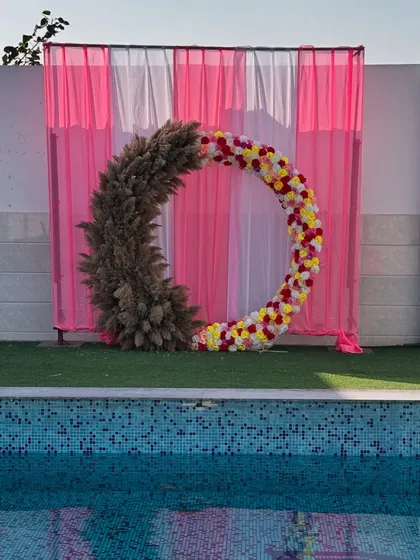 The decor sets the mood. A beautiful floral and pampas grass ring by the pool, part of a wedding event we catered.