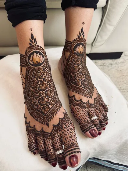 This is a classic, full-coverage foot design, featuring a central lotus, scalloped edges, and dense geometric patterns for a truly bridal or grand festive feel.