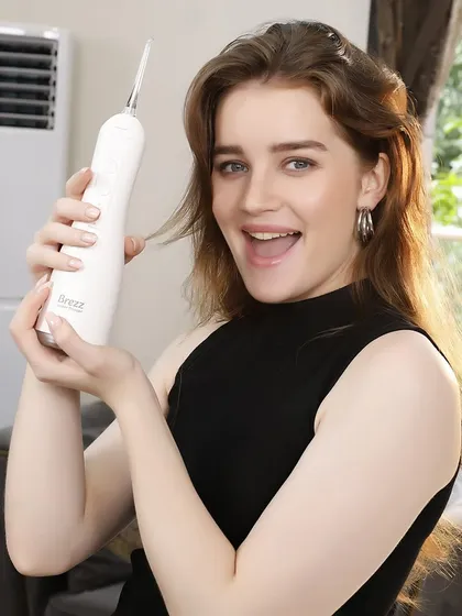 An expressive shot of a model enjoying using the white water flosser. This lifestyle image is perfect for creating an emotional connection and showing the product in a positive light.