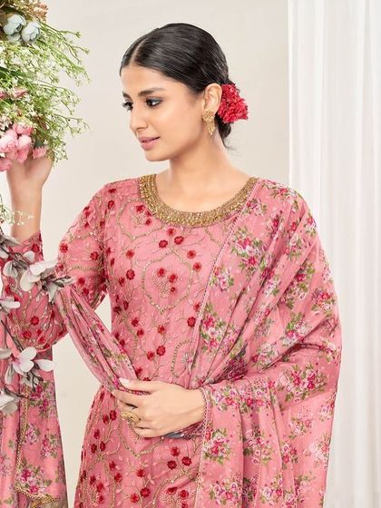 A modern take on a classic Punjabi suit. This chiku and pink net suit features a cape-style dupatta and dhoti pants, perfect for someone who loves to experiment with their style.
