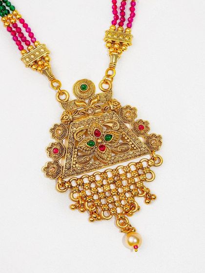 A detailed close-up of a traditional gold pendant necklace on a simple white fabric background. This is a perfect example of clean e-commerce photography that highlights product detail.