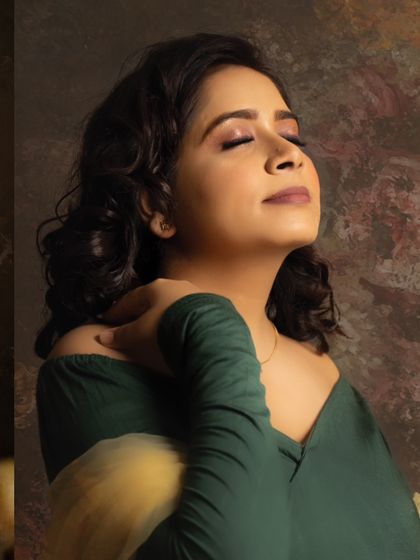 A close-up capturing a moment of pure peace. The soft lighting on her face and the rich tones of the backdrop create a serene and artistic portrait.