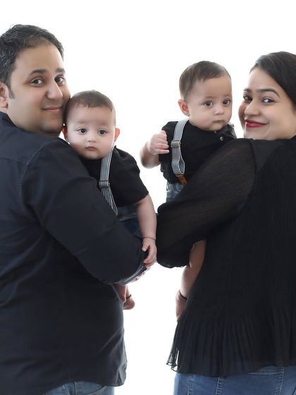 A beautiful family portrait with twin babies. Each parent holds one of the boys, creating a lovely, symmetrical, and heartwarming image of their new family.